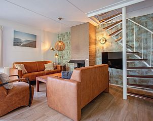 Gezellige woonkamer in Villapark Residentie Texel nr. 719, vakantiehuis in De Cocksdorp, Texel met stijlvolle zithoek en open haard.