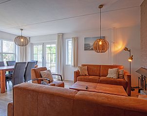 Gezellige woonkamer in Villapark Residentie Texel nr. 719, vakantiehuis in De Cocksdorp, Texel, met comfortabele banken en sfeervolle verlichting.