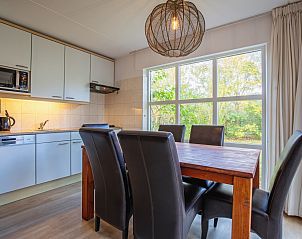 Gezellige eetkamer van Villapark Residentie Texel nr. 719 in De Cocksdorp, vakantiehuis op Texel met uitzicht op groene omgeving.