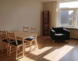 Gemtliche Essecke im Ferienhaus Kikkerpoel, De Cocksdorp, Texel mit Holztisch und Sthlen am groen Fenster.