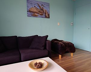 Stilvolle Sitzecke im Ferienhaus Kikkerpoel, De Cocksdorp, Texel mit Sofa und Kunst an der Wand.