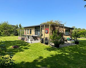 Bungalowpark Slufteroord - De Bolhoed in De Cocksdorp, Texel biedt een zonnig terras met groen uitzicht voor ultiem vakantieplezier.