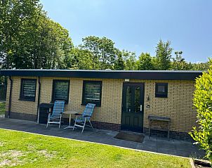 Ontspannen buitenruimte van Bungalowpark Slufteroord - De Bolhoed in De Cocksdorp, Texel, omgeven door groen.