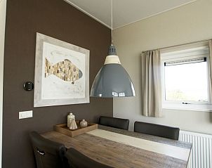 Eethoek in Chalet 11 Newport, De Cocksdorp, Texel met moderne hanglamp en kunstwerk aan de muur.