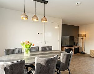Lichte eetkamer in Duinoord Texel vakantiehuis, De Cocksdorp, met moderne stoelen en hanglampen.