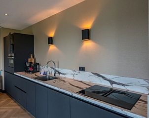 Moderne keuken in 6 persoons vakantiewoning, De Cocksdorp, Texel met marmeren aanrecht en sfeervolle verlichting.