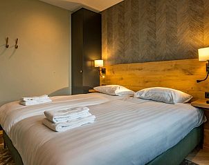 Slaapkamer in 6 persoons vakantiewoning, De Cocksdorp, Texel met comfortabel bed en warme verlichting.