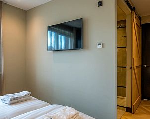 Slaapkamer met televisie in 6 persoons vakantiewoning, De Cocksdorp, Texel met moderne badkamer toegang.