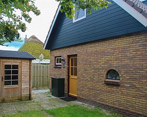 Achterzijde van bungalow Duif met houten schuurtje in Texel.