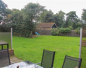 Uitzicht op de tuin van bungalow Duif in Texel met speelruimte.