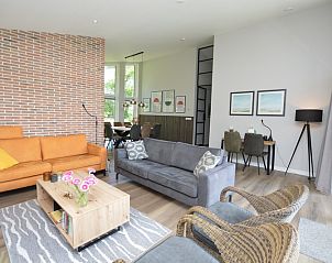 Lichte woonkamer in Orchismient 49, De Koog, Texel met elegante decoratie en meubilair.