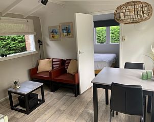 Gezellige woonkamer van vakantiehuis Hoog Koog 12 in Bungalowpark Hoog Koog, De Koog, Texel, met comfortabele zithoek en eethoek.