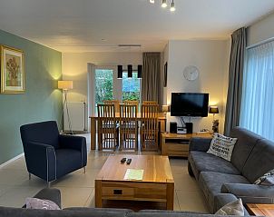 Cozy living room in vacation home Vogelmient 55, De Koog, Texel with modern furnishings and garden views.