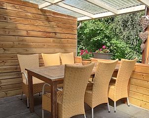 Geniet van de rust op het terras van Bungalowpark 't Hoogelandt - Carpe Diem Texel in De Koog, met uitzicht op weelderig groen.