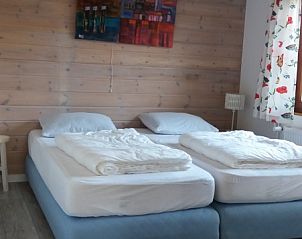 Slaapkamer in Bungalowpark 't Hoogelandt - Carpe Diem Texel, De Koog, met comfortabele bedden en sfeervolle inrichting op de Waddeneilanden.