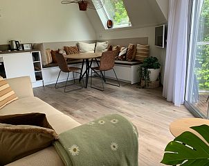 Gemtlicher Innenbereich von De Pelikaan Apartments - HeerlijkopTexel in De Koog, Texel, mit bequemer Sitzecke und viel Tageslicht.