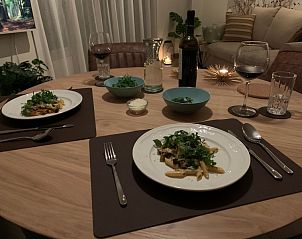 Gemtliches Esszimmer in De Pelikaan Apartments, De Koog, Texel, mit stimmungsvoll gedecktem Tisch fr ein intimes Abendessen im Ferienhaus.