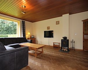 Gezellige woonkamer van Landhuis Landleven Nr. 81 in De Koog, Texel met comfortabele zithoek en houtkachel.