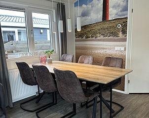 Gezellige eetkamer in Chaletpark Bregkoog, Chalet Bregkoog 232, De Koog, Texel met uitzicht op duinlandschap en comfortabele stoelen.