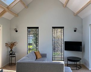 Stijlvolle woonkamer in De Houtsnip vakantiehuis, De Koog, Texel met hoge plafonds en comfortabele zithoek.