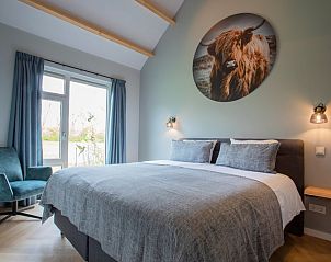 Comfortabele slaapkamer in De Houtsnip vakantiehuis, De Koog, Texel met groot bed en rustgevende decoratie.