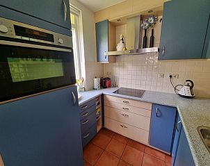 Moderne keuken van Residentie Californi - Geborchenheit - 361, Texel, met blauwe kasten en apparatuur.