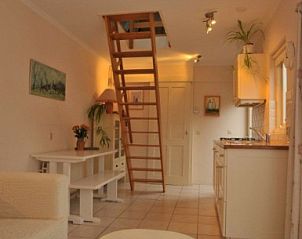 Binnenruimte van Dunaa vakantiehuis in De Koog, Texel met open keuken en trap.