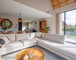 Gezellige woonkamer met grote ramen in Villa Flo, De Koog, Texel.