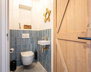 Stijlvolle badkamer met houten deur in Villa Flo, De Koog, Texel.