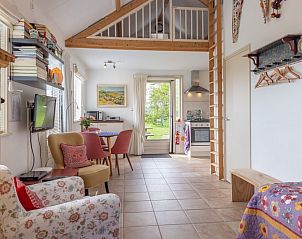 Open leefruimte in 't Paviljoen, De Koog, Texel met toegang tot tuin en veel natuurlijk licht.