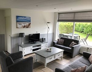 Lichte woonkamer met uitzicht op de tuin in Bungalow 33, De Koog, Texel op de Waddeneilanden.