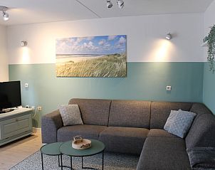 Gezellige woonkamer van De Zeedistel - Appartement Zeedistel 14 in De Koog, Texel. Comfortabele zithoek met strandthema decor.