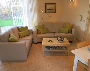 Gezellige woonkamer van Bungalow 't Luwe Land 49 in De Koog Texel, met comfortabele banken en uitzicht op de natuur van de Waddeneilanden.