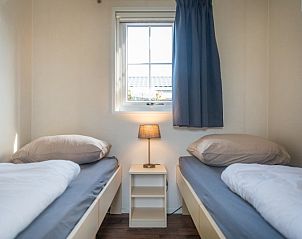 Gezellige tweepersoonskamer in Chalet Bregkoog 227, Texel, met natuurlijke lichtinval en comfortabele bedden.