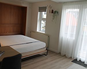 Slaapkamer van De Zeedistel - Appartement Zeedistel 16 in De Koog, Texel, met comfortabel bed en veel natuurlijk licht.