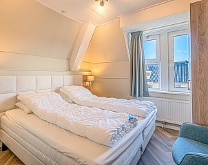 Gezellige slaapkamer in Appartement Zeedistel 22, De Koog, Texel, met comfortabele bedden en veel natuurlijk licht.