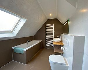 Moderne badkamer in Villapark Kamperfoelie vakantiehuis De Koog Texel, met ligbad en stijlvolle inrichting.