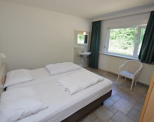 Ruime tweepersoonsslaapkamer in Epelaan 31 vakantiehuis, De Koog, Texel, met uitzicht op de groene omgeving.