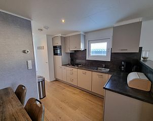 Bright kitchen of Chalet Bregkoog 103 on Chaletpark Bregkoog in De Koog, Texel with dining table.