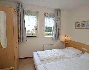 Sfeervolle slaapkamer in Vakantiehuis 7K, De Koog, Texel met twee eenpersoonsbedden.