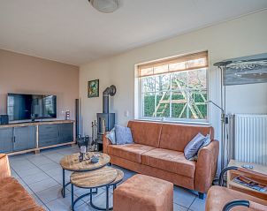 Moderne woonkamer in vakantiehuis Maaikeduinweg 13, De Koog, Texel, met flatscreen-tv en sfeervolle inrichting op de Waddeneilanden.