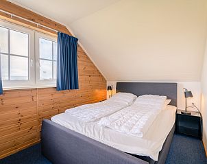 Sfeervolle slaapkamer met tweepersoonsbed in vakantiehuis Maaikeduinweg 13, De Koog, Texel, voor een goede nachtrust.