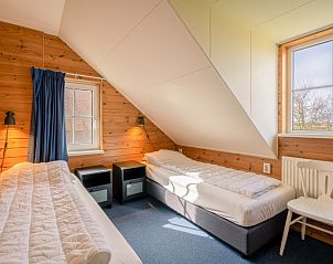 Knusse slaapkamer met twee eenpersoonsbedden in vakantiehuis Maaikeduinweg 13, De Koog, Texel, perfect voor kinderen.