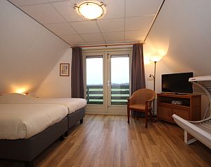 Tweede slaapkamer in Villa, De Koog, Texel, met balkon en uitzicht op de natuur van de Waddeneilanden.