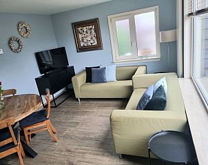 Gezellige woonkamer in Vakantiehuis 1, De Koog, Texel met comfortabele banken en een eethoek.