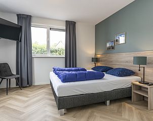 Cozy bedroom in Villa 39 De Koog Texel with large window and double bed.