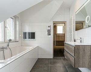 Wellness bathroom in Villa 39 De Koog Texel with bath and sauna facilities.