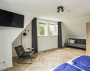Seating area in Villa 39 De Koog Texel with modern decor and views of greenery.