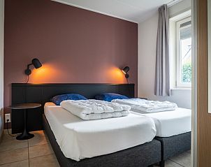 Comfortabele slaapkamer in Bungalow 15a, De Koog, Texel, met tweepersoonsbed en sfeervolle verlichting.