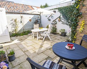 Zonnig terras van Bungalow 9708 in De Koog, Texel met gezellige zithoek en parasol.